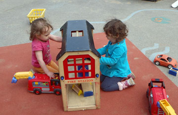 Image of young girls playing with a toy Fire Station